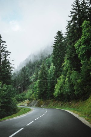 Foto de Carretera vacía con una góndola y nubes pesadas en los árboles cercanos Chtel, Francia - Imagen libre de derechos