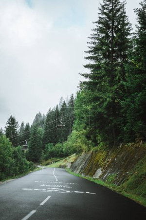 Téléchargez les photos : Route vide avec une gondole et de gros nuages sur les arbres à proximité de Chtel, France - en image libre de droit
