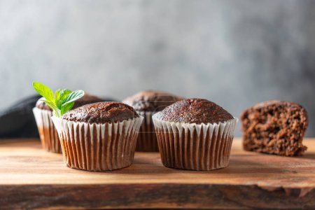 Chocolate muffins on a wooden stand. Close up.