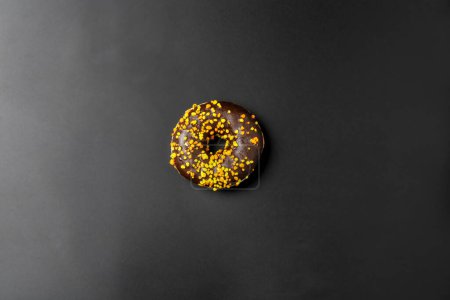 Chocolate donut on a black background. Top view with space for text.