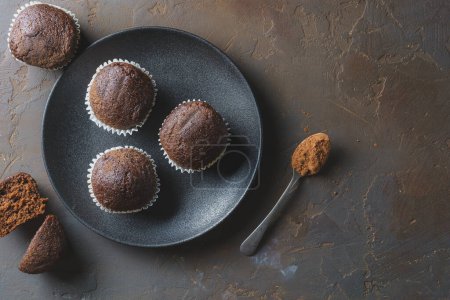 Muffins on a black plate and on a concrete table. Top view, with space for text.