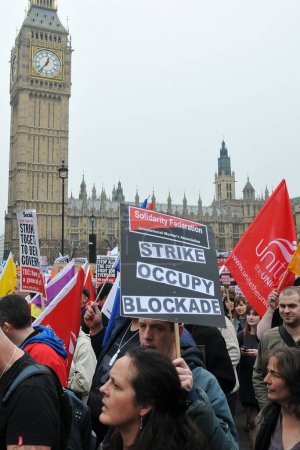 Photo for LONDON - MARCH 26: A group of protesters march through the streets of the British capital during a large TUC organized anti-cuts rally on March 26, 2011 in London, UK. - Royalty Free Image