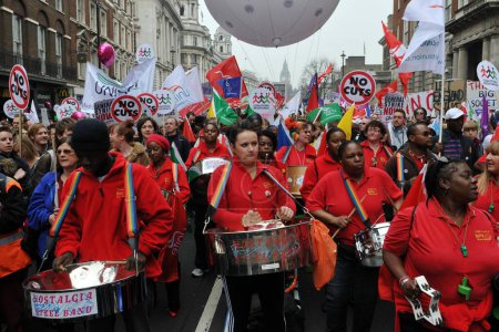 Téléchargez les photos : LONDRES - 26 MARS 2011 : Un groupe d'acier joue alors que les manifestants manifestent contre les réductions de dépenses dans le secteur public 26 mars 2011, à Londres, au Royaume-Uni. Environ 250 000 personnes ont assisté au rassemblement organisé par le TUC. - en image libre de droit