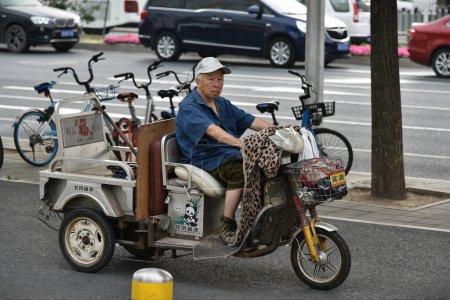 Téléchargez les photos : BANGKOK, THAÏLANDE - 2 MARS 2012 : Un taxi tuk à trois roues roule le long d'une route à Chinatown - en image libre de droit