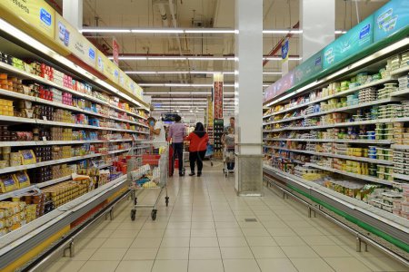 Foto de Los compradores navegan por un pasillo en un supermercado de Carrefour el 8 de diciembre de 2018 en Dubai, Emiratos Árabes Unidos. El Carrefour de Francia es una de las cadenas de supermercados más grandes del mundo con Walmart de Estados Unidos y Tesco del Reino Unido. - Imagen libre de derechos