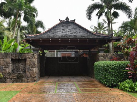 Téléchargez les photos : Vue d'une maison et porte d'entrée ornée sur une rue sur une île tropicale - en image libre de droit