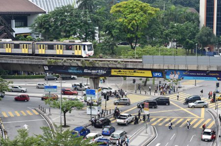 Téléchargez les photos : Les gens et la circulation passent par le centre-ville le 19 juin 2015 à Kuala Lumpur, en Malaisie. La capitale malaisienne est bien desservie par les infrastructures de transport et les systèmes de transport en commun. - en image libre de droit