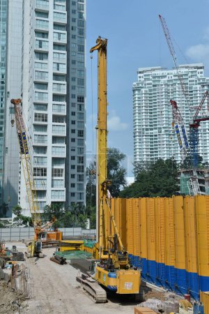 Foto de Grúas y trabajadores trabajan en un sitio de construcción del centro de la ciudad el 19 de junio de 2015 en Kuala Lumpur, Malasia. La capital malaya está viendo un auge de la construcción con nuevas construcciones comerciales y residenciales. - Imagen libre de derechos