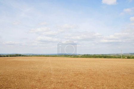 Téléchargez les photos : Paysage rural pittoresque vue sur la terre agricole nue avec un beau ciel au-dessus - en image libre de droit