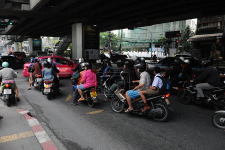 Foto de Un mototaxi transporta a un pasajero en una calle de la ciudad el 10 de agosto de 2011 en Bangkok, Tailandia. Los taxis de motos son una opción popular para las carreteras muy congestionadas de la capital tailandesa. - Imagen libre de derechos