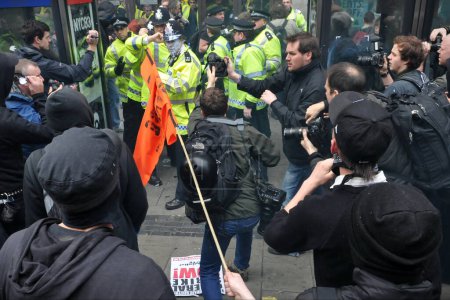 Téléchargez les photos : Garde de police sur le pont Westminster sous Big Ben lors d'un grand rassemblement d'austérité le 26 mars 2011 à Londres, Royaume-Uni. La police était en attente après de violents affrontements avec des manifestants anti-gouvernementaux. - en image libre de droit