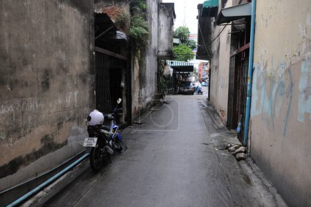Foto de Un callejón oscuro y angosto se ve en el centro de la ciudad el 10 de agosto de 2011 en Bangkok, Tailandia. La capital tailandesa tiene una red de calles secundarias conocidas como sois, donde la vida cotidiana se desarrolla en las calles. - Imagen libre de derechos