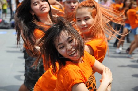 Téléchargez les photos : Une troupe de danse flash majorette se produit dans une rue du centre-ville le 30 juin 2013 à Bangkok, en Thaïlande. Les équipes de danse Cheerleading gagnent en popularité dans la capitale thaïlandaise et en Asie du Sud-Est. - en image libre de droit