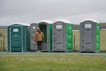 Foto de La gente usa baños portátiles el 21 de marzo de 2023 en Amesbury, Reino Unido. Los baños portátiles se utilizan a menudo en grandes eventos públicos al aire libre que no albergan las instalaciones sanitarias necesarias. - Imagen libre de derechos