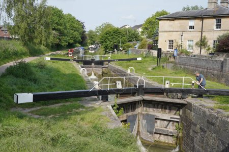 Téléchargez les photos : Une écluse est vue sur le canal de Kennet et Avon le 28 mai 2023 à Devizes, au Royaume-Uni. La ville de Wiltshire est réputée pour son approche montagneuse sur le canal et ses nombreuses écluses. - en image libre de droit