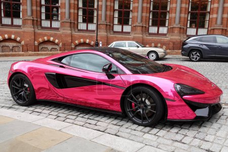 Foto de Un superdeportivo Mclaren 540C Coupe S-A V8 VVT Twin Turbo SSG rosa metálico se ve estacionado en una calle del centro de la ciudad el 31 de julio de 2023 en Londres, Reino Unido. - Imagen libre de derechos