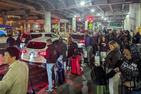 Photo for People wait for transport at JFK Airport on October 30, 2023 in New York City, USA. The pick up point was overwhelmed with passengers waiting for taxis, private cars and buses. - Royalty Free Image