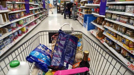 Téléchargez les photos : Un chariot rempli de produits alimentaires est poussé le long d'une allée du supermarché Sainsburys le 19 octobre 2023 à Londres, au Royaume-Uni. Sainsburys est le deuxième plus grand détaillant de supermarchés de Grande-Bretagne après Tesco avec 1400 magasins. - en image libre de droit