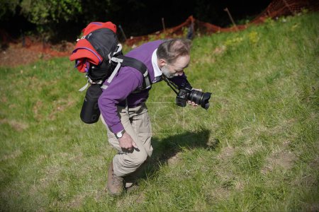 Téléchargez les photos : Un photographe grimpe Cooper Hill le 29 mai 2023 à Brockworth, au Royaume-Uni. Cooper's Hill est une destination de voyage célèbre dans la ville du Gloucestershire, connue pour son approche raide et ses vues à couper le souffle. - en image libre de droit