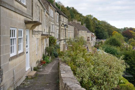 Scenic view of a stone path running past old terraced cottage houses in a beautiful English town - namely the historic town of Bradford on Avon in Wiltshire England