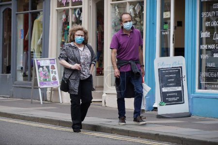 Foto de Los compradores usan máscaras faciales a medida que se introduce una nueva ley que exige el uso de máscaras en las tiendas el 24 de julio de 2020 en Bath, Reino Unido. El uso de máscaras faciales es para combatir la pandemia de Covid-19. - Imagen libre de derechos