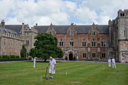 Téléchargez les photos : Les gens jouent au croquet sur une pelouse au palais épiscopal de la cathédrale historique de Wells, le 20 août 2020 à Wells, au Royaume-Uni. La ville historique de Somerset est décrite comme la plus petite ville du Royaume-Uni. - en image libre de droit