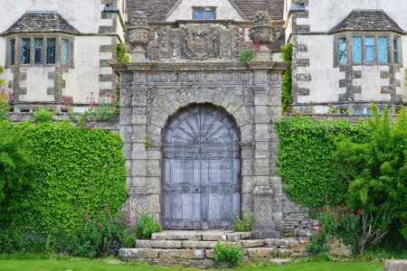 Foto de Vista exterior de una puerta de entrada adornada y la pared circundante de una antigua mansión tradicional en una calle en un pueblo Inglés - Imagen libre de derechos