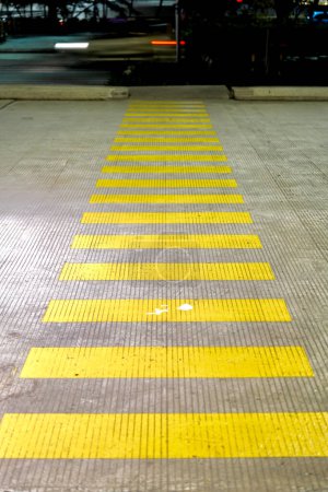 Yellow pedestrian crossing on concrete road during the night.