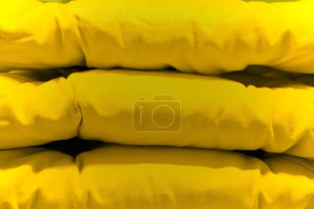 Yellow chair cushion foam stacked with one another.