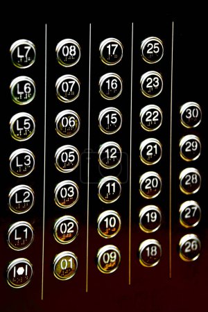 A section of lift floor destination selector, illuminated in luxurious black-golden lighting.