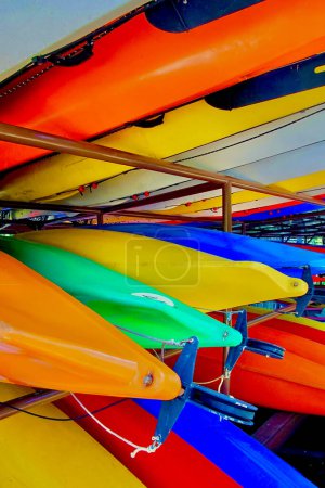 A multiple colorful Kayak stacked in storage ready to use.