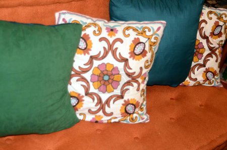 Photo for An orange couch with a variety of colorful cushions closeup image. - Royalty Free Image