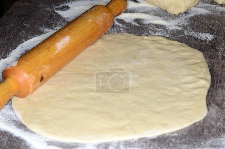 Photo for A Pizza dough and wooden roller in preparation for Pizza night. - Royalty Free Image
