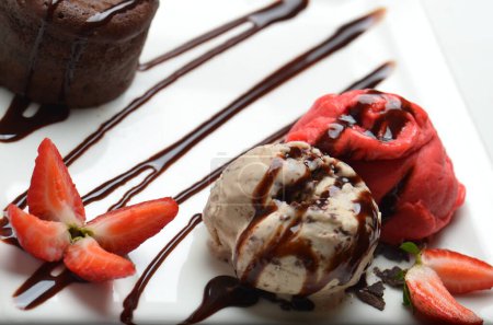 Pastel de fondant de chocolate, pastel de lava fundida con fresa y helado de vainilla y bayas frescas en el plato.