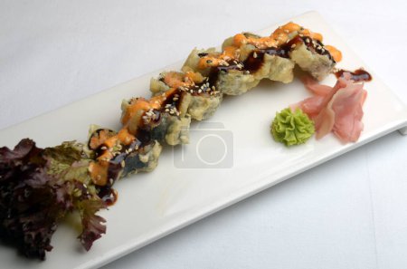 Assiette de Sushi fraîchement préparée et tranchée, servie avec wasabi et gingembre mariné isolé sur fond blanc.