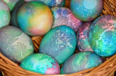 Photo for Easter holiday dyed eggs placed in a straw basket. - Royalty Free Image