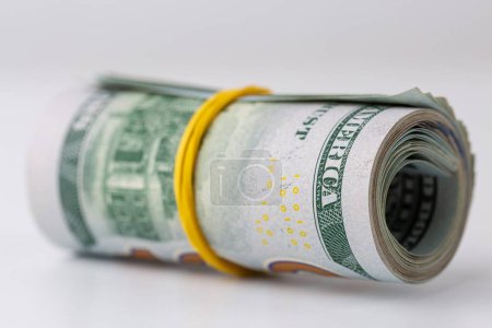 Rolled 100 dollar bill on isolated white background