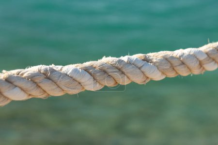 Téléchargez les photos : Braided rope on the background of the blue sea. - en image libre de droit