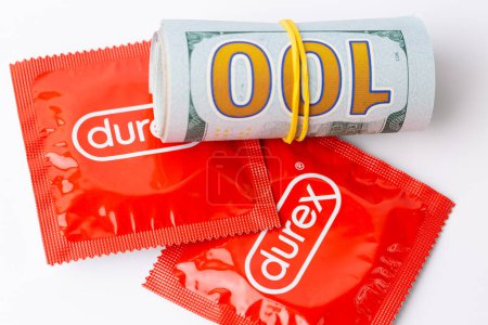 Foto de Una imagen de un paquete rojo de preservativos Durex junto con billetes de dólar. - Imagen libre de derechos