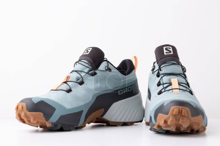Foto de Nuevos zapatos de trekking de la marca Salomon, impermeables con membrana gore-tex sobre fondo blanco. - Imagen libre de derechos