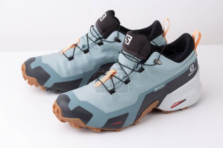 Téléchargez les photos : Nouvelles chaussures de trekking de la marque Salomon, imperméables avec une membrane gore-tex sur fond blanc. - en image libre de droit