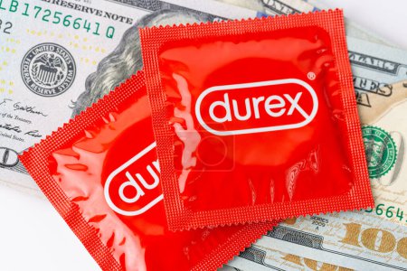 Foto de Una imagen de un paquete rojo de preservativos Durex junto con billetes de dólar. - Imagen libre de derechos