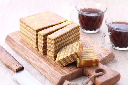 Photo for A stack of chocolate cake with a slice of coffee on a wooden table - Royalty Free Image