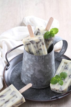 Photo for Ice cream with mint and vanilla sticks on a wooden background - Royalty Free Image