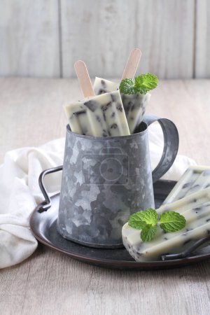 Photo for Ice cream with mint and vanilla sticks on wooden background - Royalty Free Image