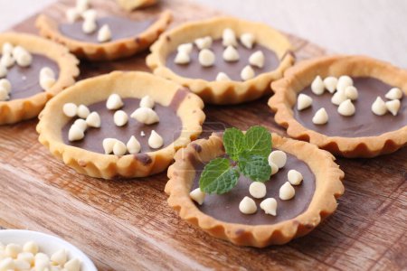 Téléchargez les photos : Chocolate muffins with mint leaves on a wooden background - en image libre de droit