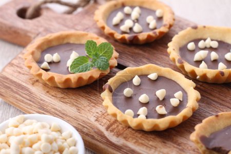 Téléchargez les photos : Muffins au chocolat faits maison avec des feuilles de menthe et des baies sur fond en bois - en image libre de droit