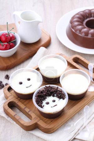Foto de Rosquillas de chocolate con café y leche en una mesa de madera - Imagen libre de derechos