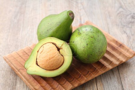 Photo for Avocado fruit on a wooden cutting board on the kitchen table - Royalty Free Image