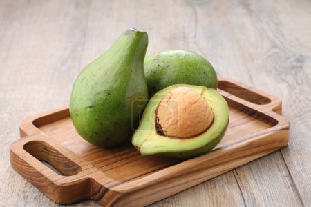 Téléchargez les photos : Avocado fruit on a wooden cutting board on the kitchen table - en image libre de droit